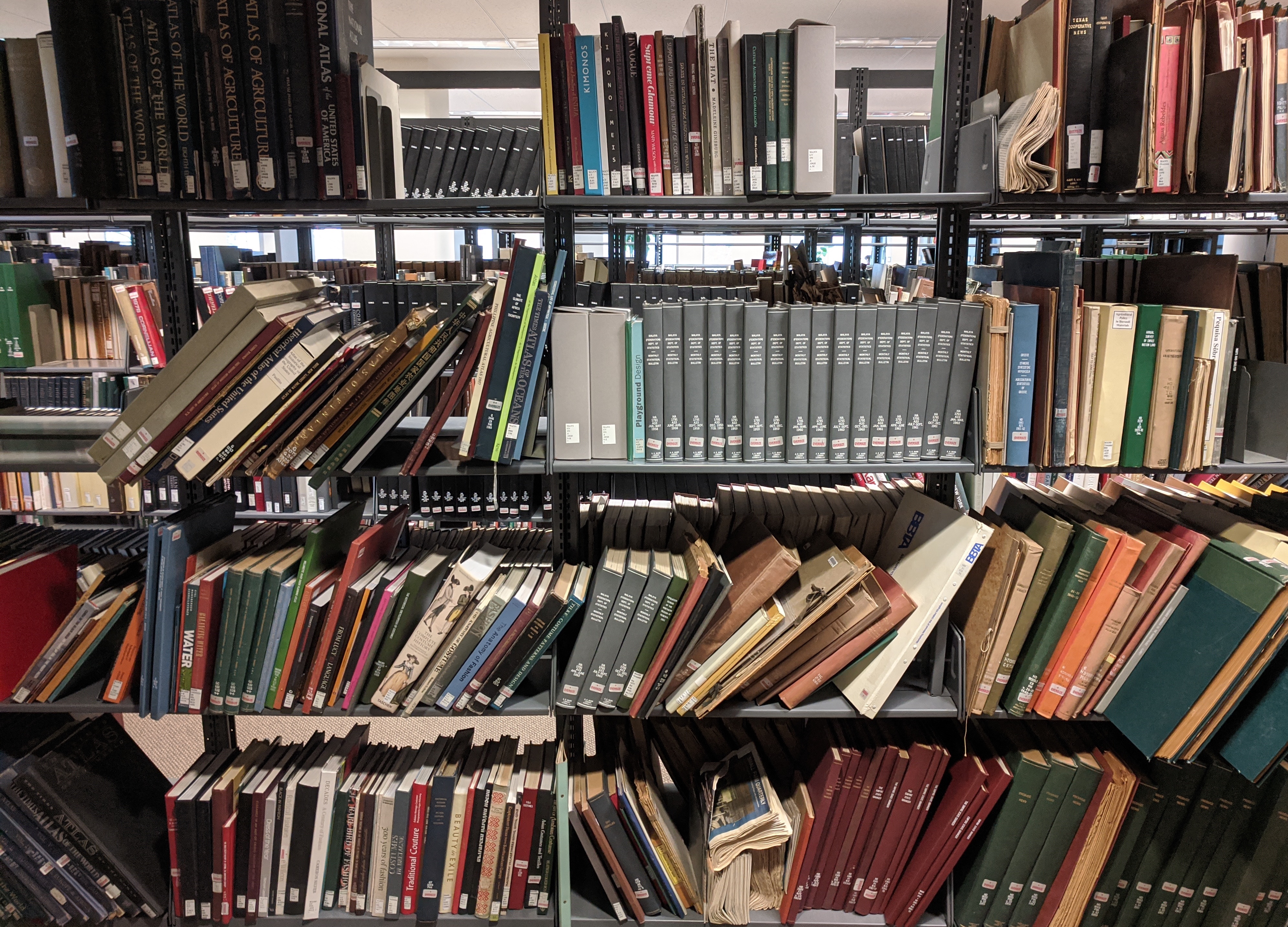 A photograph of many books on a shelf at odd angles