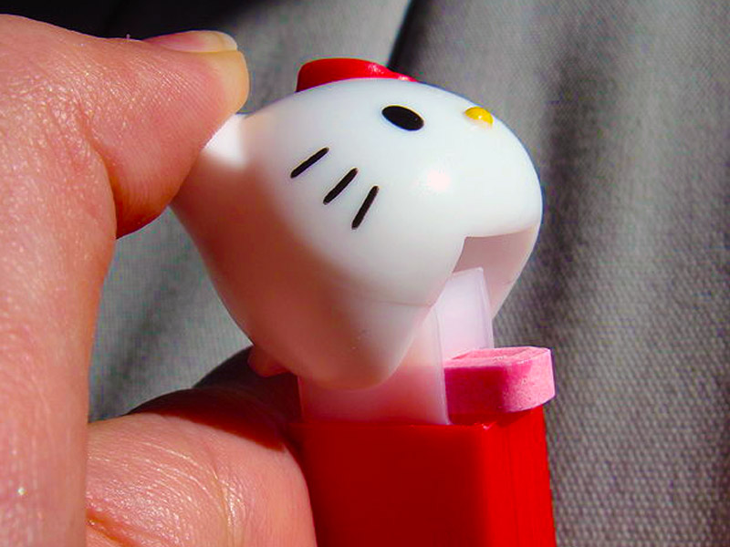 A Pez dispenser in action, featuring the head of Hello Kitty